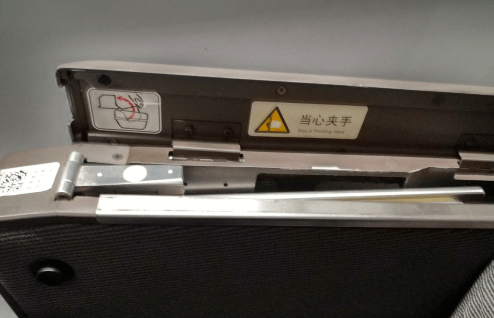 開蓋后可以看到一塊金屬板，這個就是藏起來的高鐵小桌板，向上將其拉出。
